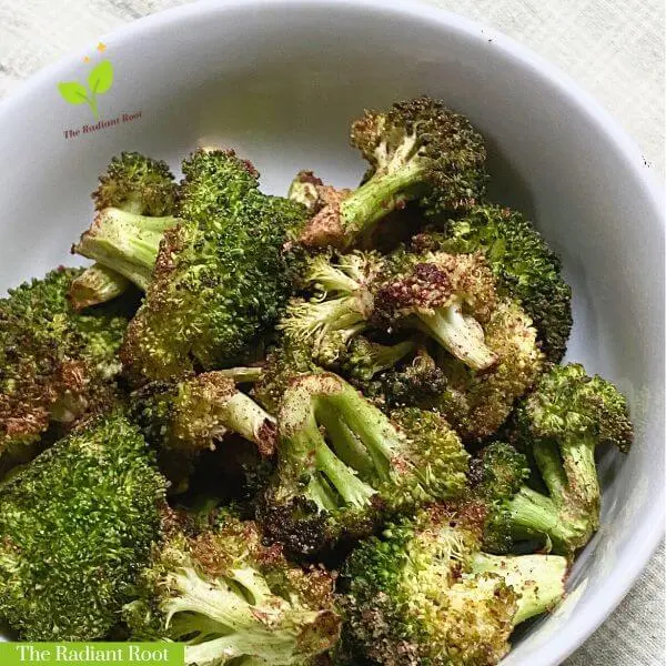 Roasted cinnamon broccoli in a white bowl with the words "The Radiant Root" on the bottom left | The Radiant Root