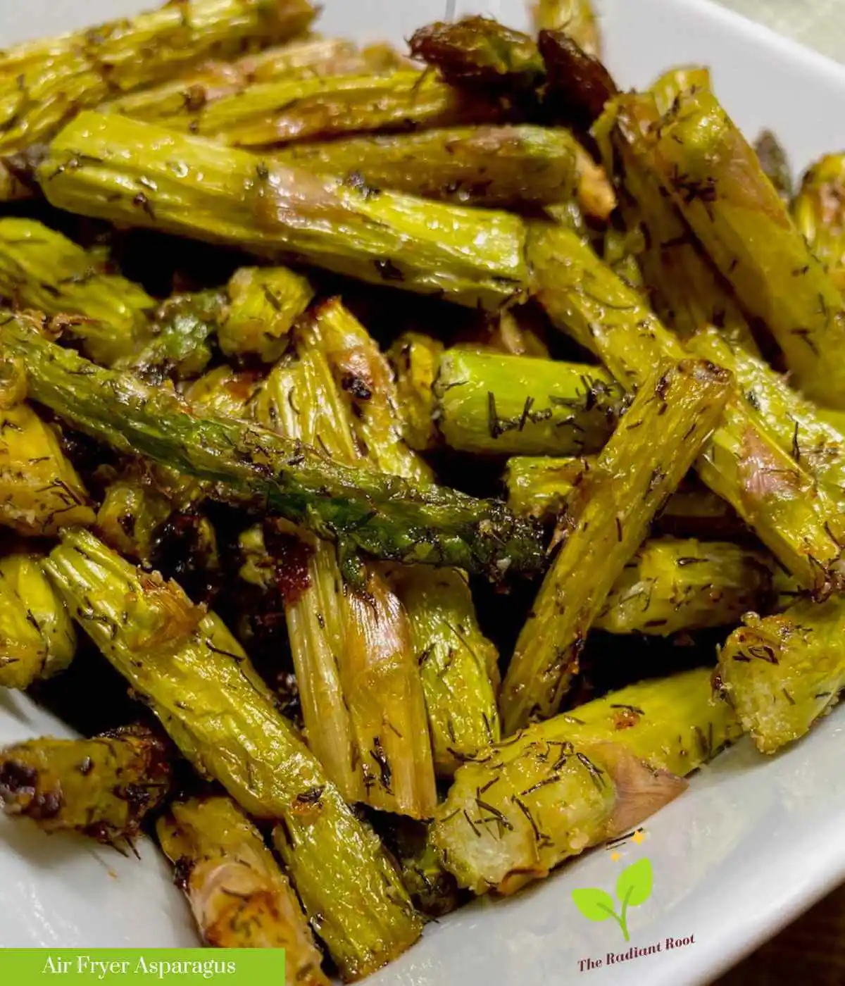A white dish overflowing with air fried asparagus bite-size pieces | asparagus in the air fryer | The Radiant Root