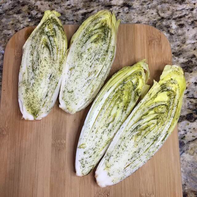 Raw Endives Cut Long ways with Dill and Olive Oil Mixture on wooden cutting board | The Radiant Root