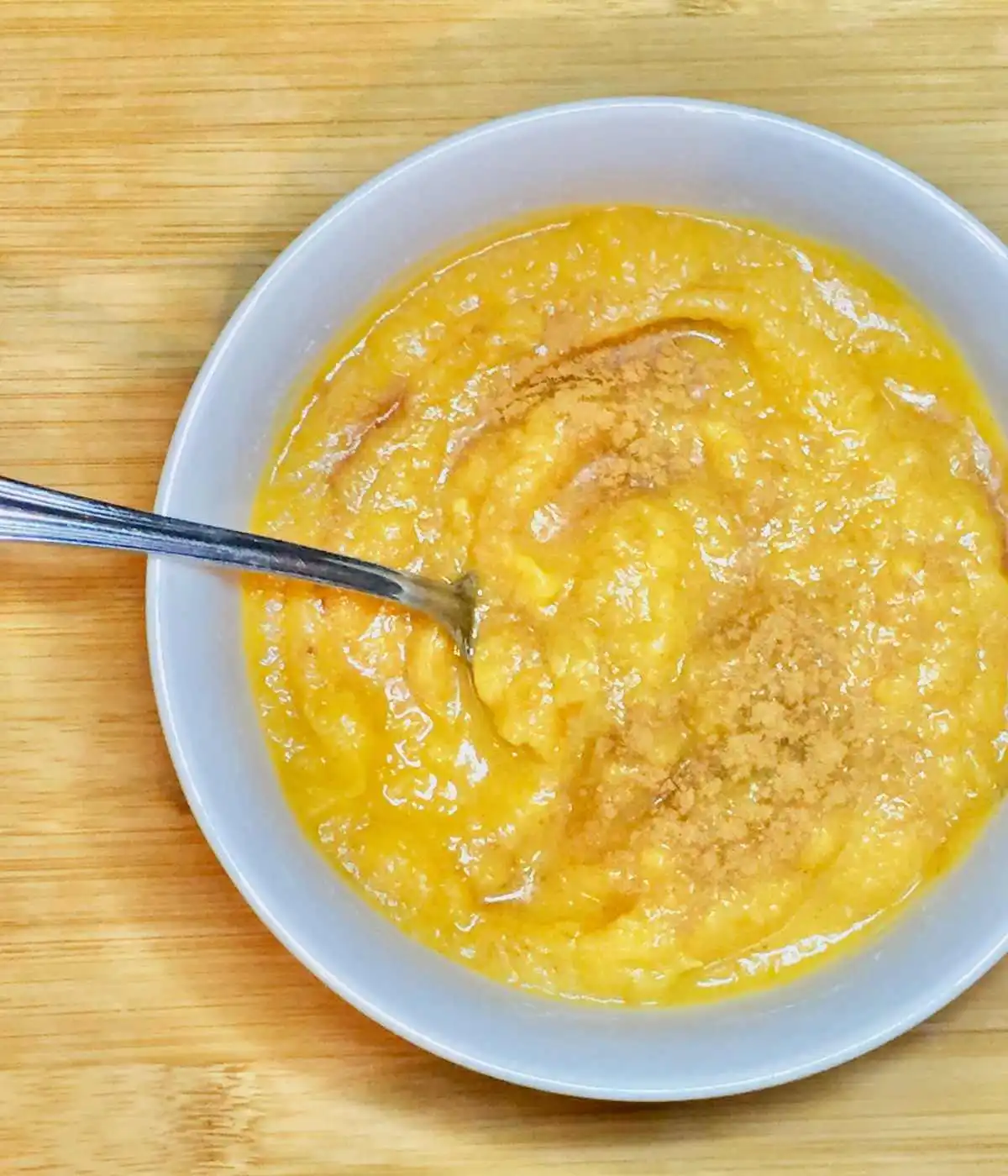 Ginger sweet potato soup in a white bowl with a silver spoon | The Radiant Root