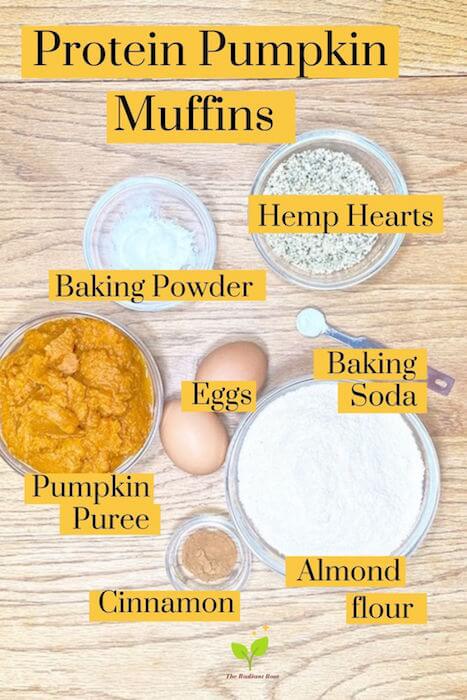 Protein Pumpkin Muffins ingredients in small bowls on a wooden table: almond flour, pumpkin puree, baking powder, baking soda, cinnamon, eggs | The Radiant Root