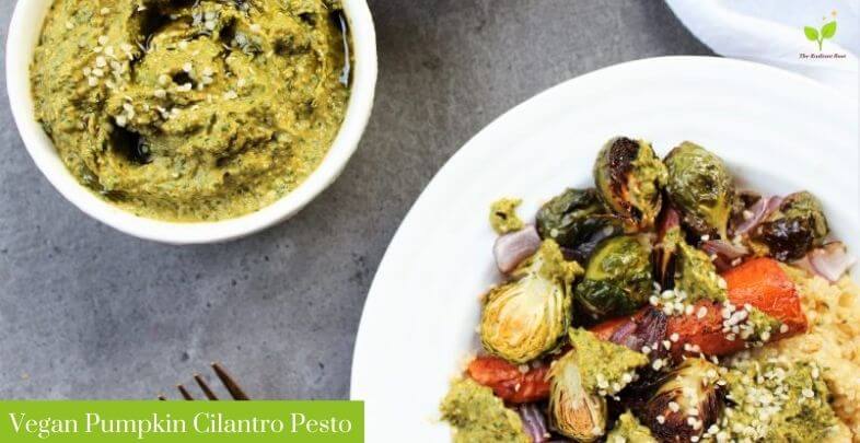 Vegan Pumpkin Cilantro Pesto over roasted vegetables in a white plate part of the hemp hearts recipes round-up | The Radiant Root