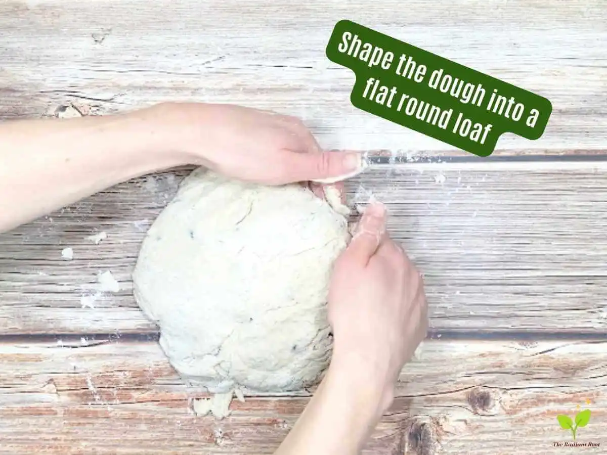 Gluten Free Irish Soda Bread Instruction 9 of 14: A brown wooden table with hands shaping the same dough into a flat round loaf with the words that read “shape the dough into a flat round loaf.” | Gluten Free Irish Soda Bread | The Radiant Root