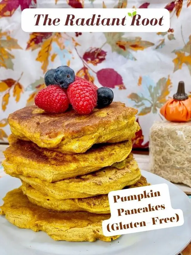 Pumpkin Pancakes (Gluten-Free): At the top it reads “The Radiant Root.” A close-up photo of the finished gluten free pumpkin pancakes in a stack on a white plate topped with blueberreis and raspberries with a fall backdrop showing fall leaves. At the bottom it reads “Pumpkin Pancakes (gluten- free).” | pumpkin spice pancakes | The Radiant Root