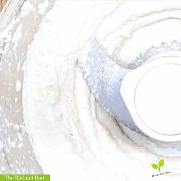 Cashew cream WP Recipe Photo: A close up image of a finished cashew cream in a food processor bowl with the words “The Radiant Root” in the lower left hand corner. | cashew | The Radiant Root