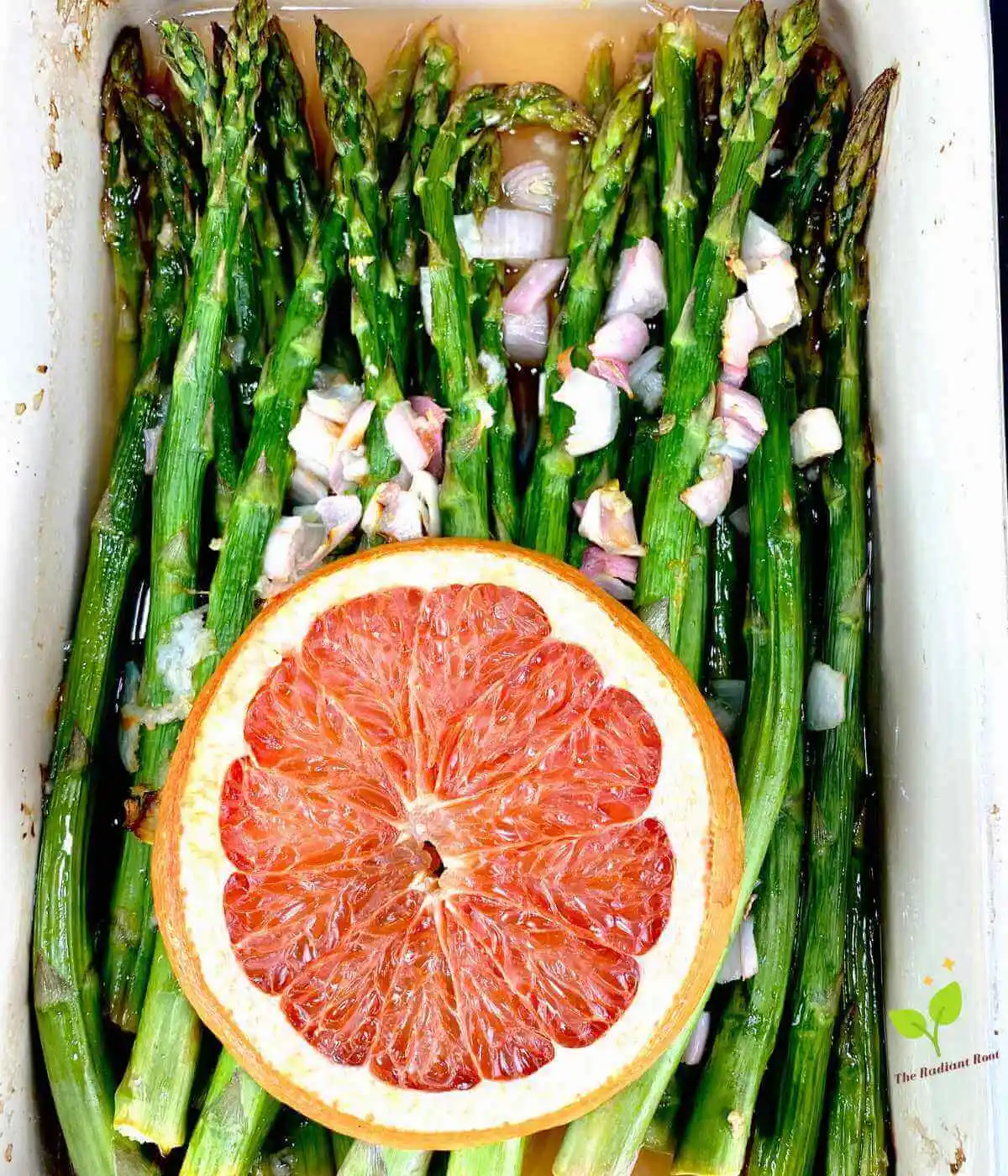 Asparagus with Shallots main photo: Close up photo of roasted asparagus with shallots in a white dish topped with a marinade of grapefruit juice, lemon juice, shallots, garlic, and extra virgin olive oil, topped with a grapefruit slice garnish. | asparagus roasted | The radiant Root
