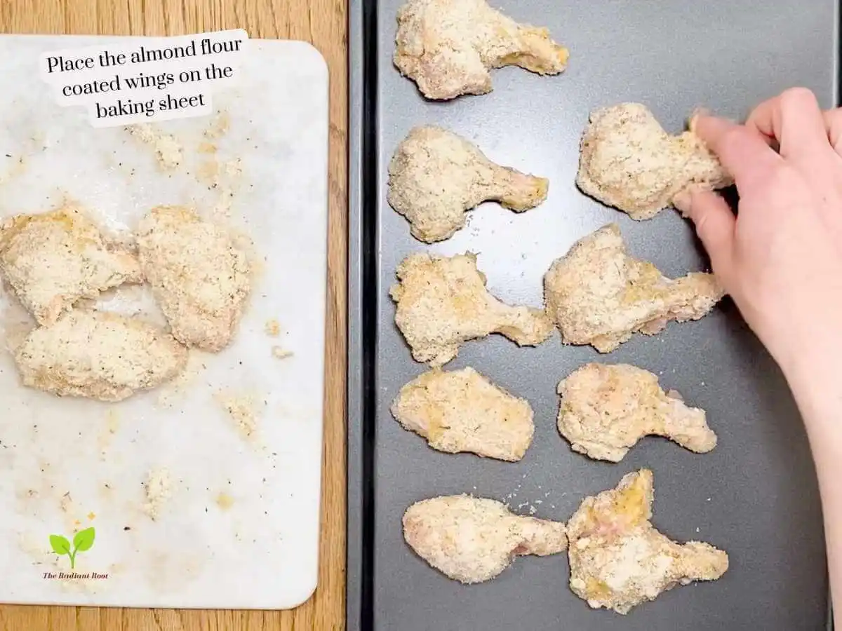 GF Chicken Wings recipe instruction photo 12 of 14 : A wooden table with a rimmed baking sheet. There is a hand placing the coated chicken wings. On the left is a white marble cuttin board containing the remaining coated chicken wings. It reads “place the almond flour coated wings on the baking sheet.” | gluten free chicken wings near me | The Radiant Root