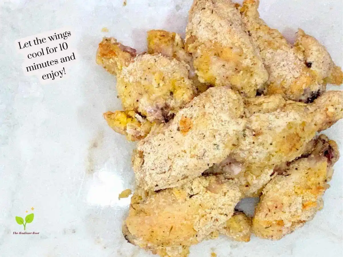 GF Chicken Wings recipe instruction photo 14 of 14 : A close up of finished almond flour coated chicken wings on a white marble cutting board. It reads “Let the wings cool for 10 minutes and enjoy!” | baked chicken wing recipe | The Radiant Root