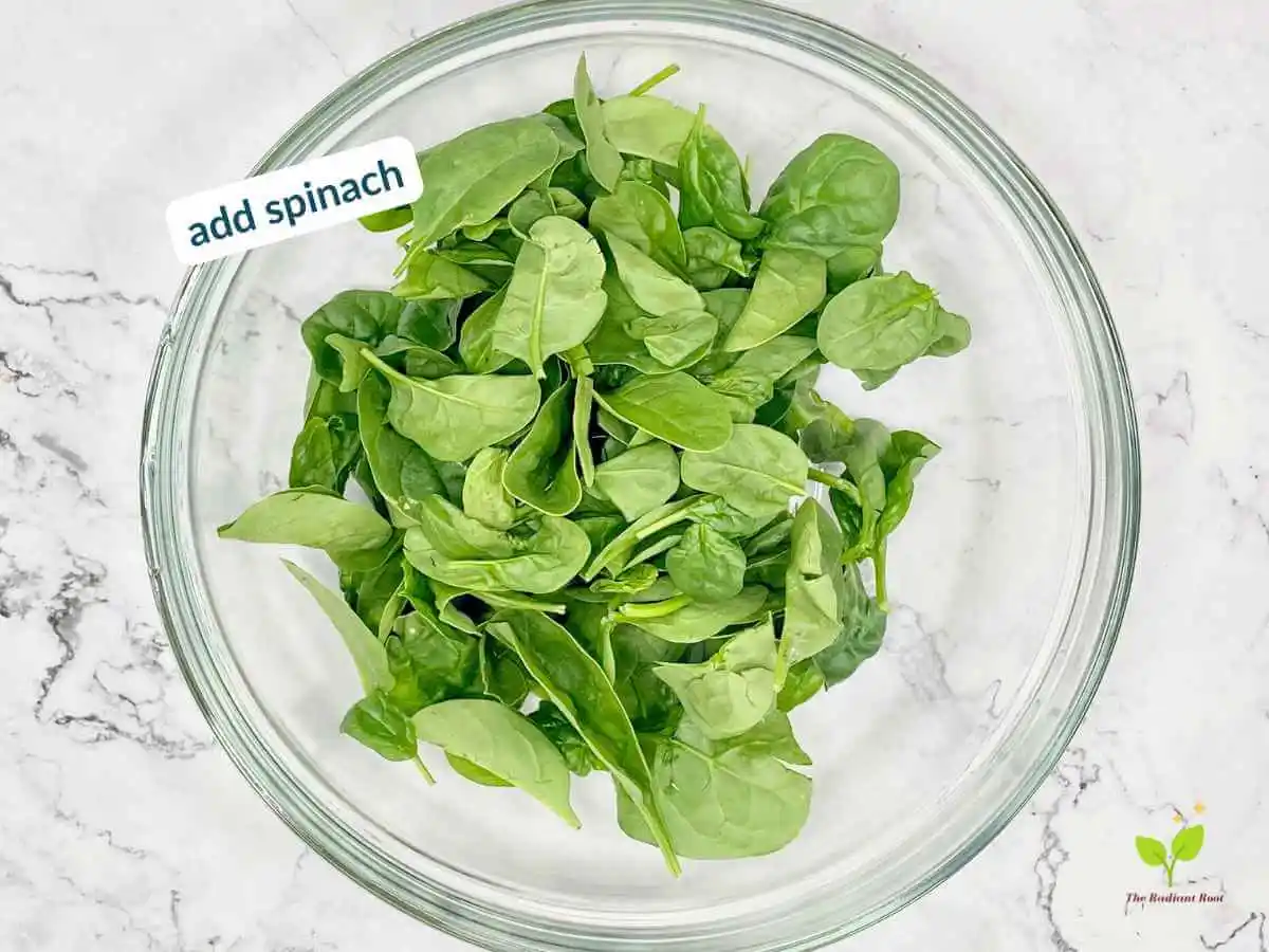 Peach Spinach Salad recipe instruction photo 4 of 12 : A white marble table containing a large clear glass mixing bowl containing spinach. In the upper left corner it reads “Add spinach.” | Fresh peaches | The Radiant Root